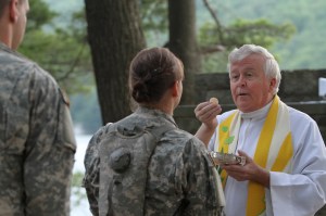 Military chaplain seves Communion in 2011 at Camp Buckner in West Point, N.Y.